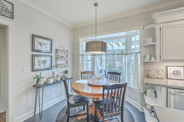 dining space with dark tile patterned floors and crown molding