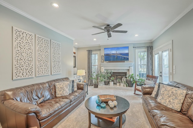 carpeted living room with ceiling fan and ornamental molding