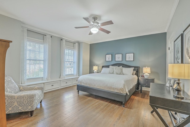 bedroom featuring hardwood / wood-style flooring, ornamental molding, and ceiling fan