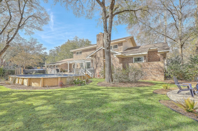 back of house featuring a pergola and a yard