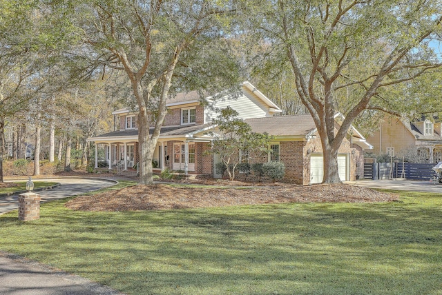 view of front of house featuring a garage, a front lawn, and covered porch