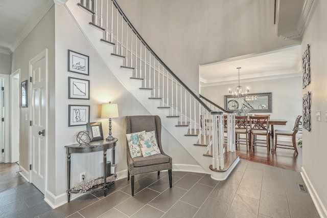 stairs with a towering ceiling, ornamental molding, and a chandelier