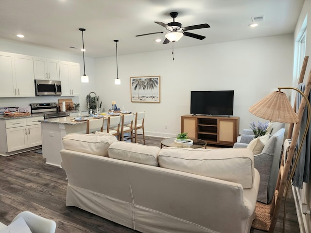 living area featuring visible vents, dark wood-type flooring, a ceiling fan, recessed lighting, and baseboards