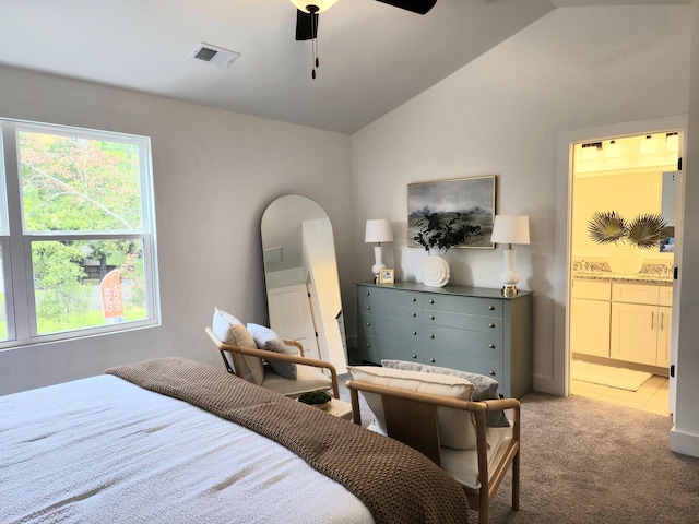 bedroom with visible vents, ceiling fan, vaulted ceiling, light carpet, and connected bathroom