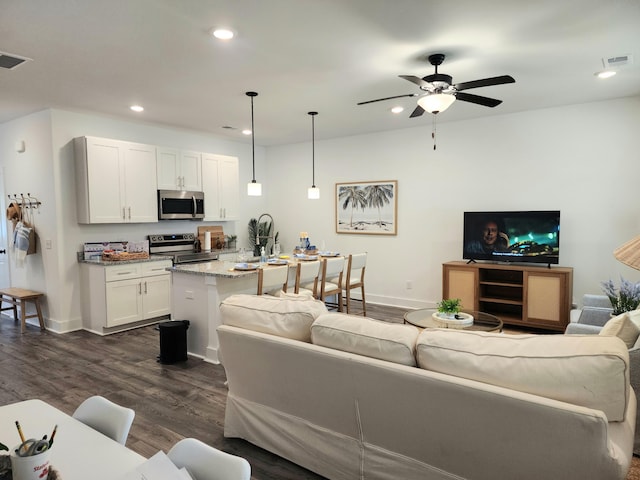 living room with dark wood finished floors, recessed lighting, visible vents, and baseboards