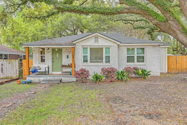 1188 Camden St, North Charleston, SC 29405 - view of front facade with roof with shingles, covered porch, fence, and brick siding