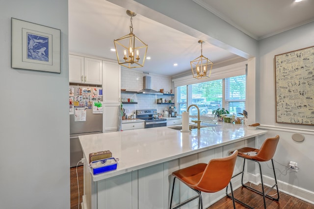 1188 Camden St, North Charleston, SC 29405 - kitchen featuring an inviting chandelier, ornamental molding, wall chimney range hood, appliances with stainless steel finishes, and a sink