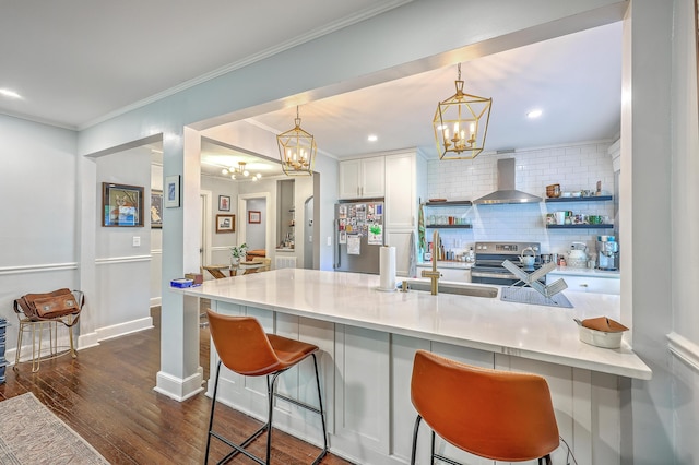 1188 Camden St, North Charleston, SC 29405 - kitchen featuring a notable chandelier, a kitchen breakfast bar, wall chimney range hood, backsplash, and appliances with stainless steel finishes