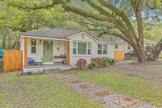 1188 Camden St, North Charleston, SC 29405 - view of front facade with a porch, roof with shingles, fence, and brick siding