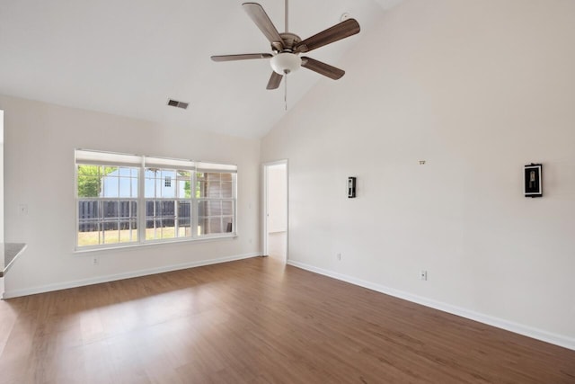 unfurnished room with high vaulted ceiling, wood finished floors, a ceiling fan, and baseboards