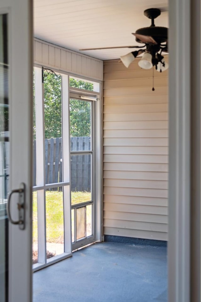unfurnished sunroom featuring ceiling fan