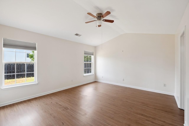 unfurnished room featuring a ceiling fan, vaulted ceiling, wood finished floors, and baseboards