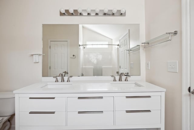 bathroom featuring toilet, double vanity, and a shower
