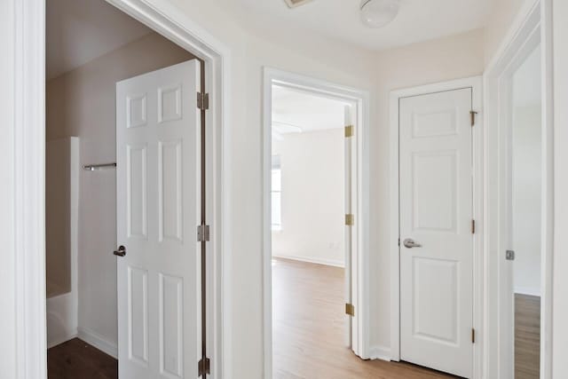 hallway with wood finished floors and baseboards