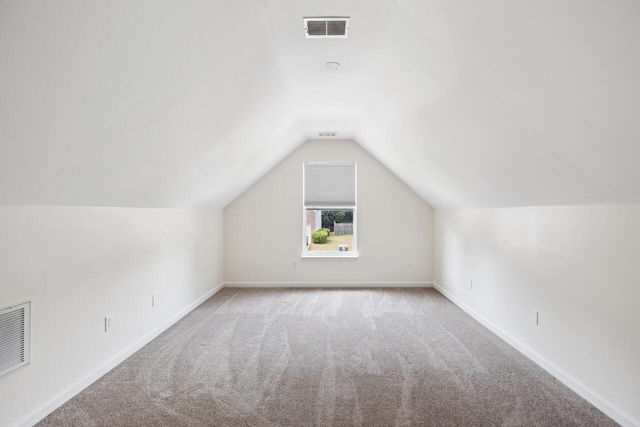 additional living space featuring carpet, lofted ceiling, and baseboards