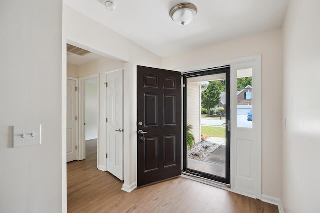 foyer featuring light wood finished floors and baseboards