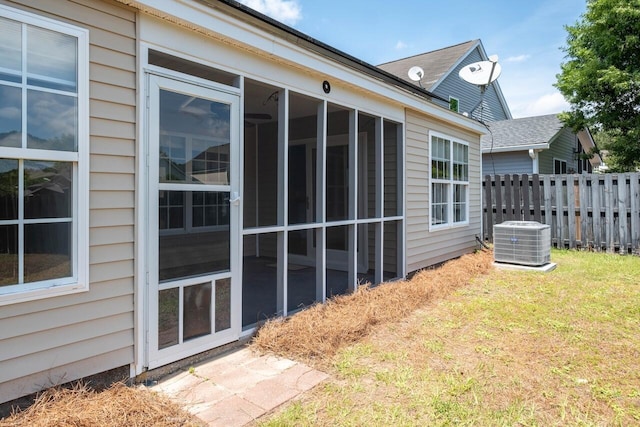 view of side of home featuring central AC and a sunroom