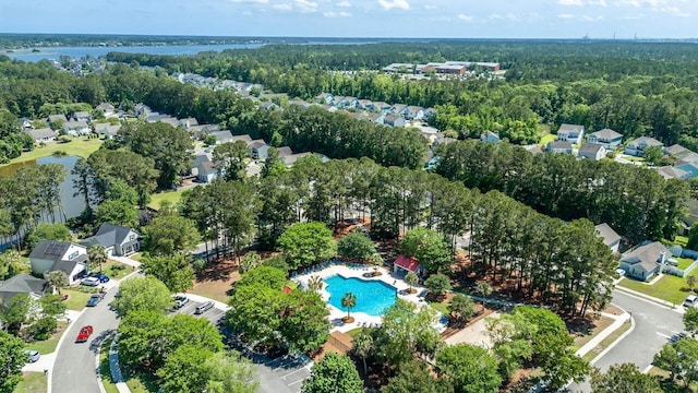 aerial view of residential area featuring a pool area and a nearby body of water