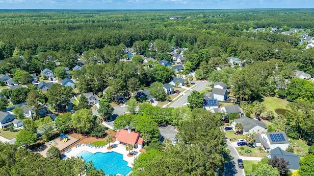 aerial view of property's location with a forest, a pool, and nearby suburban area