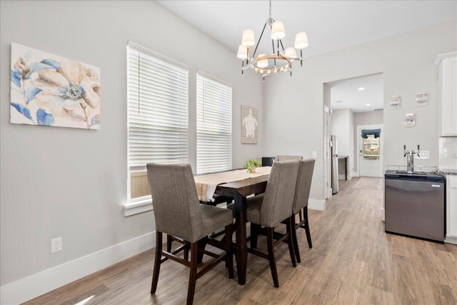 dining space featuring an inviting chandelier and light wood-type flooring