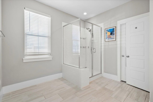 bathroom featuring a shower with door and a healthy amount of sunlight