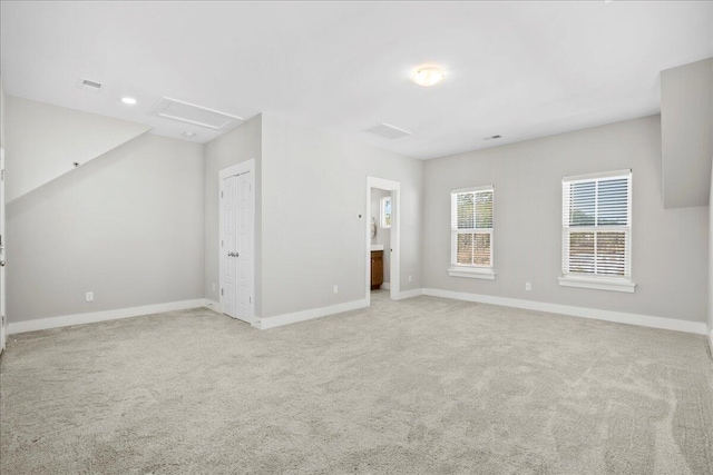 interior space featuring light colored carpet and ensuite bath