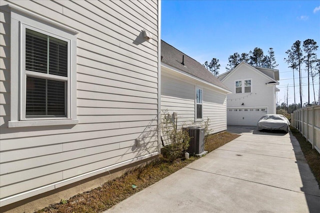 view of side of home with a garage and central AC unit