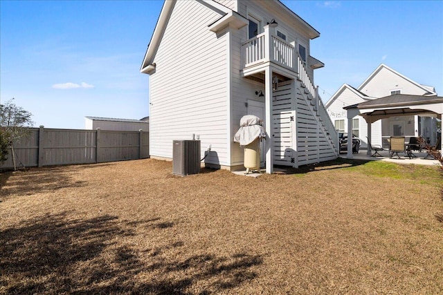 back of property featuring a patio, a balcony, a yard, central air condition unit, and a gazebo