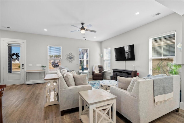 living room with ceiling fan, plenty of natural light, and dark hardwood / wood-style flooring