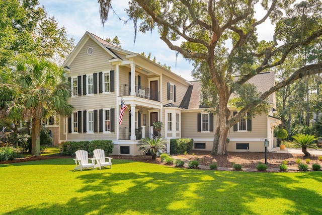 back of house with a lawn and a balcony