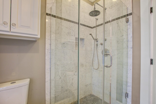 bathroom featuring a shower stall and toilet