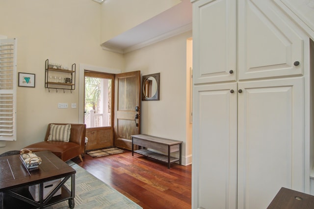 foyer with crown molding and dark wood-style flooring