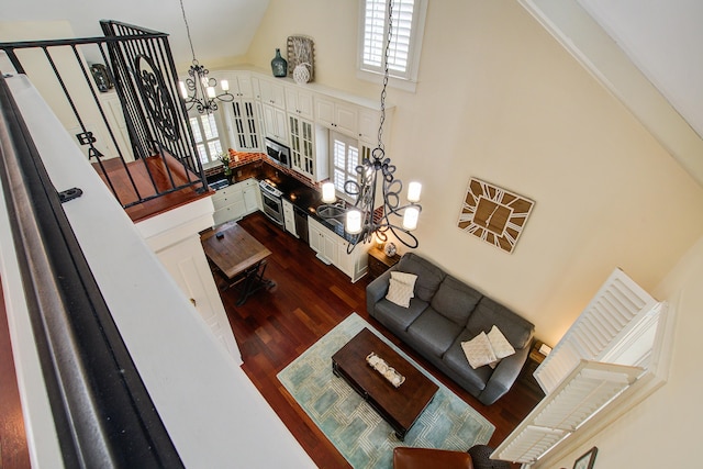 living area with high vaulted ceiling, a chandelier, and dark wood-type flooring