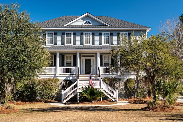 colonial inspired home with a front yard and covered porch