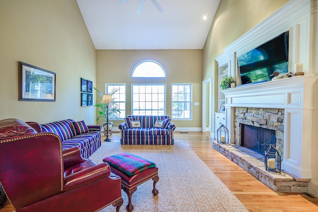 living room with high vaulted ceiling, a fireplace, wood finished floors, and baseboards