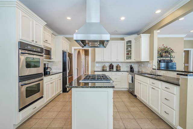 kitchen featuring light tile patterned floors, island range hood, a kitchen island, appliances with stainless steel finishes, and a sink