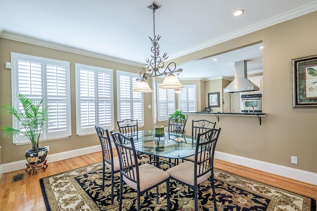 dining space featuring baseboards, ornamental molding, wood finished floors, and recessed lighting