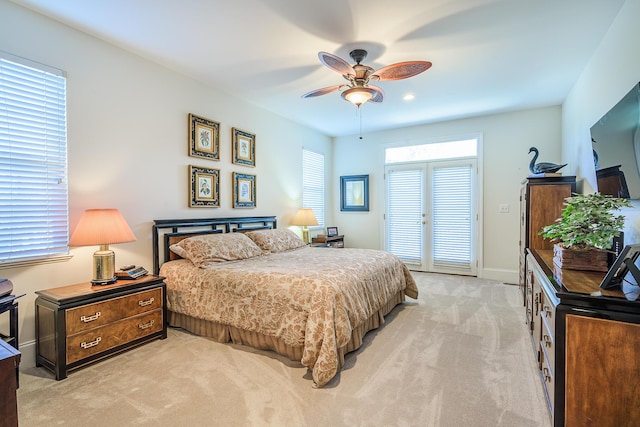 bedroom with light carpet, ceiling fan, and baseboards