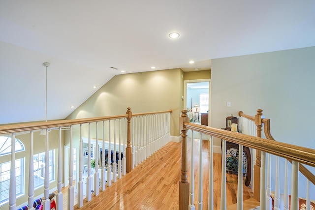 hall featuring lofted ceiling, recessed lighting, an upstairs landing, baseboards, and light wood-style floors