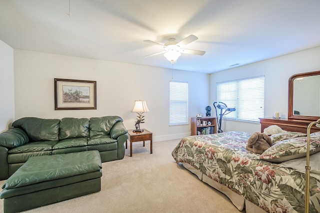 carpeted bedroom with a ceiling fan, visible vents, and baseboards