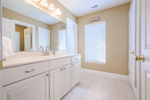 bathroom featuring baseboards, vanity, visible vents, and tile patterned floors