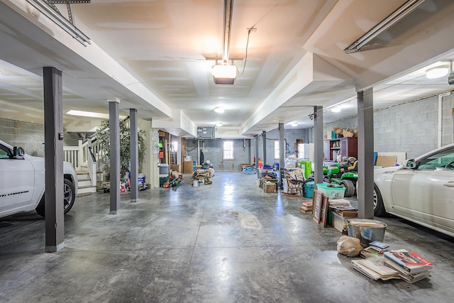 garage featuring concrete block wall and a garage door opener