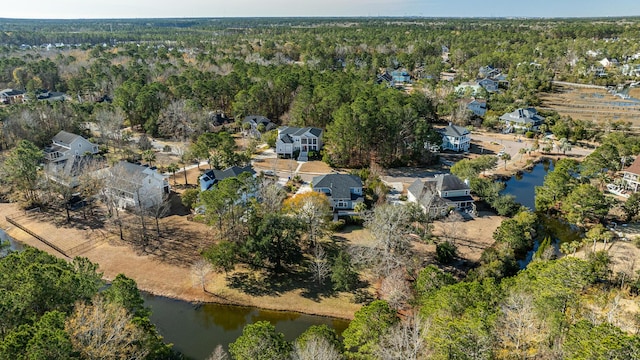 aerial view with a water view and a wooded view