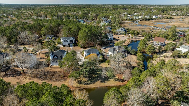 drone / aerial view featuring a water view, a residential view, and a wooded view