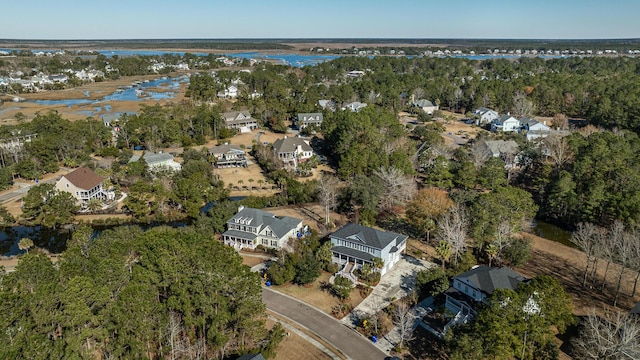 drone / aerial view with a water view, a residential view, and a view of trees