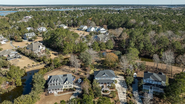 drone / aerial view with a water view and a forest view