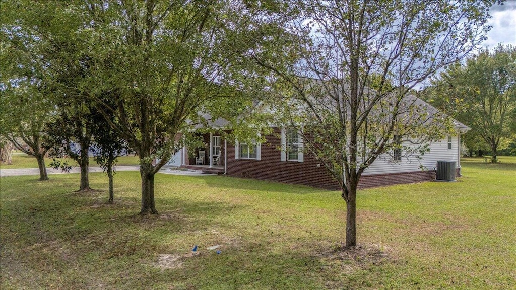 obstructed view of property with central AC and a front lawn