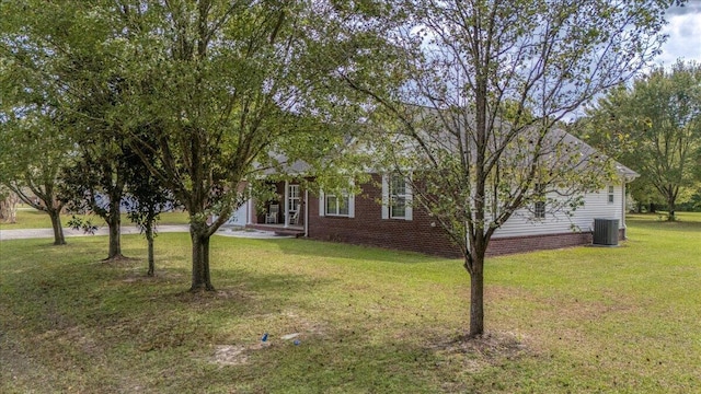 obstructed view of property with central AC and a front lawn