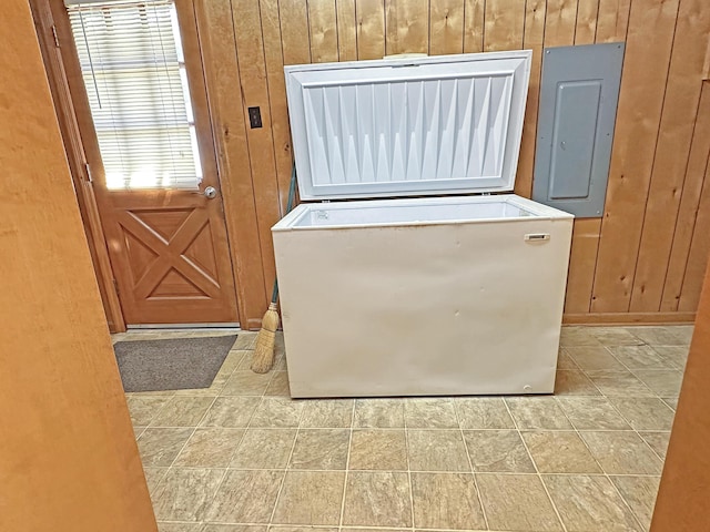 laundry room featuring wood walls and electric panel