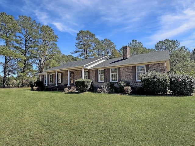 ranch-style home featuring a front yard, brick siding, and a chimney